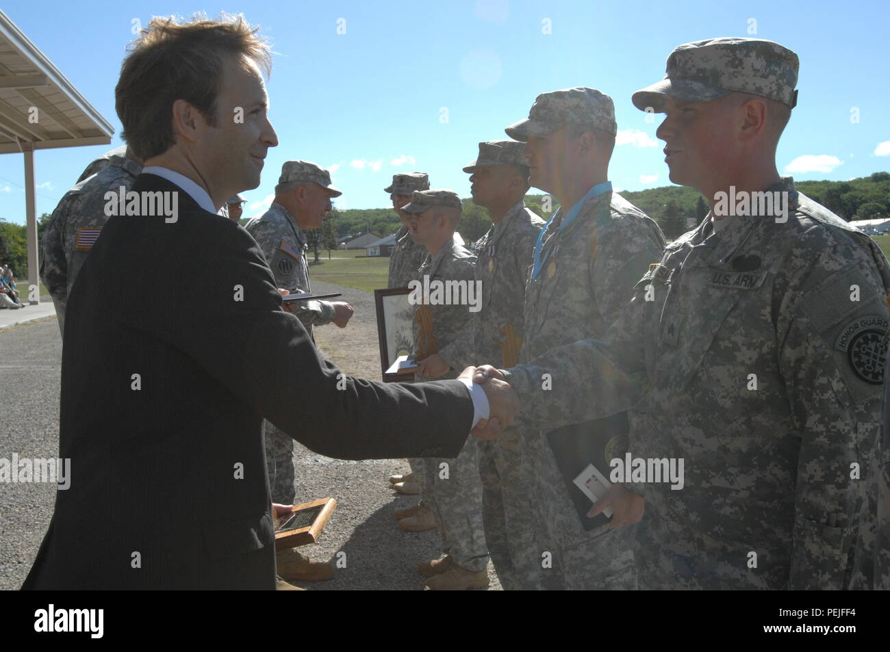 Michigan Lt. Gov. Brian Calley congratulates Sgt. David Smith of Lanse, Mich., for his selection as the State Honor Guard Member of the Year at Camp Grayling Joint Maneuver Training Center, Grayling, Mich., Aug. 21, 2015. Smith is assigned to Detachment 1, 1431st Engineer Company based in Baraga. (U.S. Air National Guard photo by Master Sgt. Denice Rankin/Released) Stock Photo