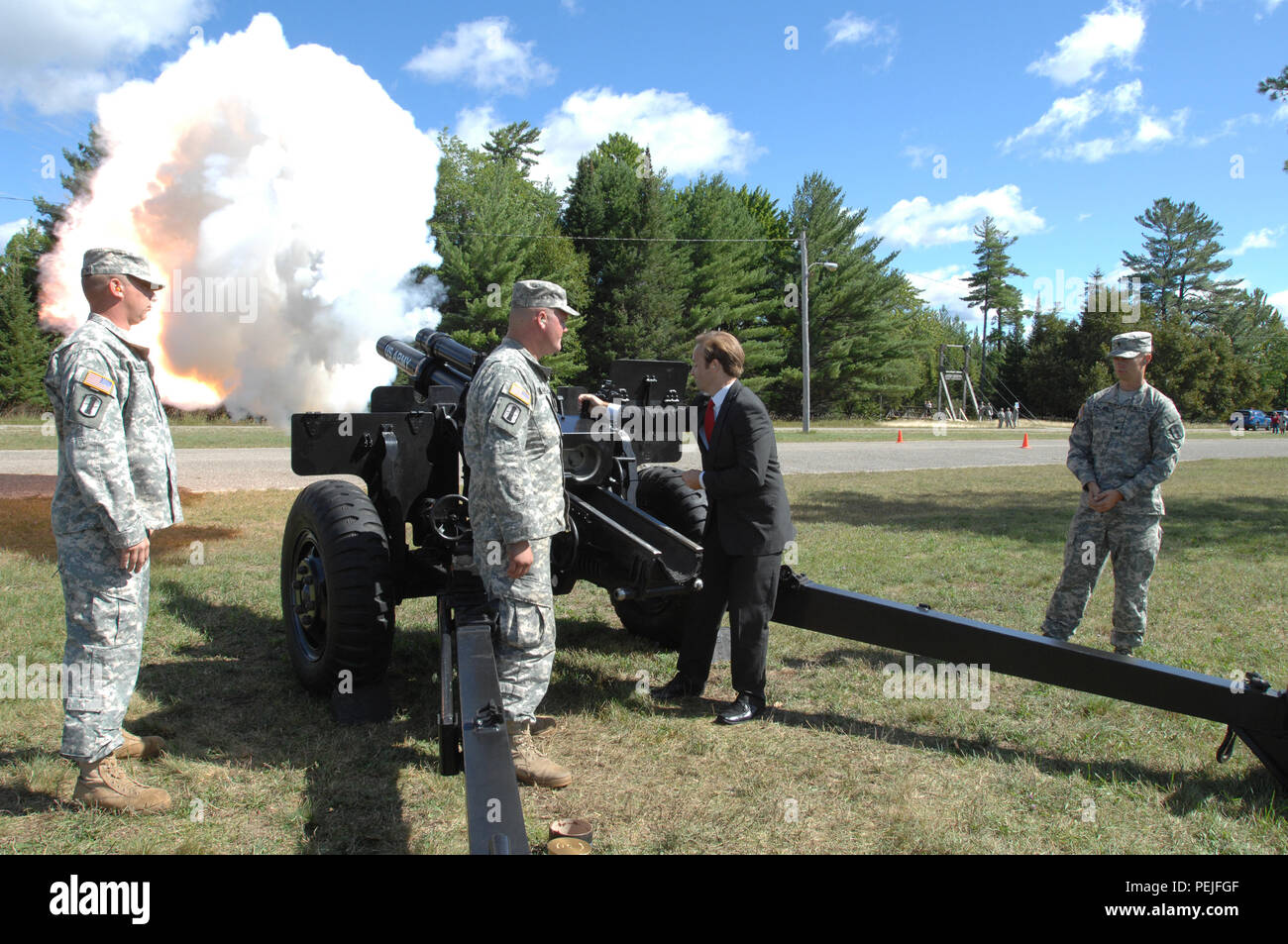 Michigan Lt. Gov. Brian Calley fires the Michigan National Guard M-777 Howitzer after the annual Pass in Review of the Troops ceremony at Camp Grayling Joint Maneuver Training Center, Grayling, Mich., Aug. 21, 2015. Calley was the keynote speaker and reiterated his thanks to the Soldiers and their families. (U.S. Air National Guard photo by Master Sgt. Denice Rankin/Released) Stock Photo