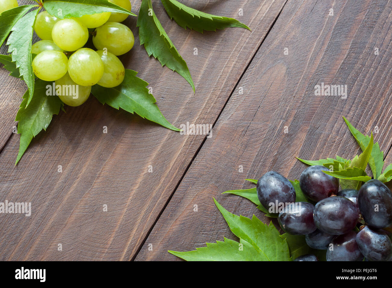 Bunch of red and white grapes on wooden table background with copy ...