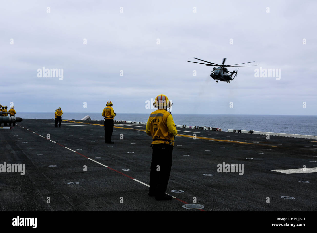 A U.S. Navy landing enlisted signalmen observes a CH-53E Super Stallion aboard the amphibious assault USS Boxer during Exercise Dawn Blitz 2015, Aug. 31, 2015. Dawn Blitz is a multinational amphibious training exercise designed to train Expeditionary Strike Group Three, 1st Marine Expeditionary Brigade and Coalition partners in the operations expected of an amphibious task force while also building U.S. and Coalition operational interoperability from the sea. (U.S. Marine Corps photo by Lance Cpl. April L. Price/Released) Stock Photo