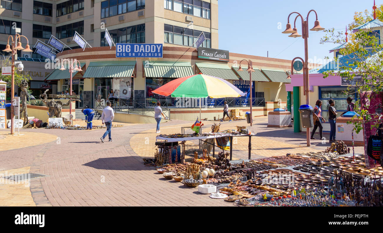 WINDHOEK, NAMIBIA - MAY 10 2018; Typical African city street scene with market wares in street surrounded by buildings and commercial signs Stock Photo