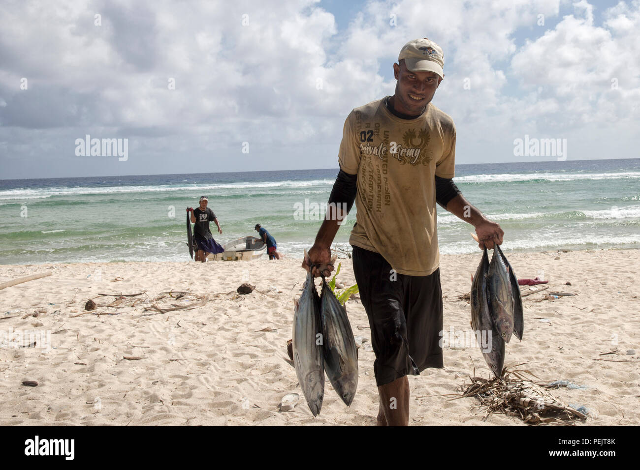 A fisherman carries tunas to a man's house at Fais Island, Federated States of Micronesia, Dec. 8, 2015. In Fais, there are three villages and one head chief who is Louis Mangtau, he divides harvests evenly. No one can  touch it until he’s finished. After that each village then takes its harvests to distribute among the families evenly. (U.S. Air Force photo by Osakabe Yasuo/Released) Stock Photo