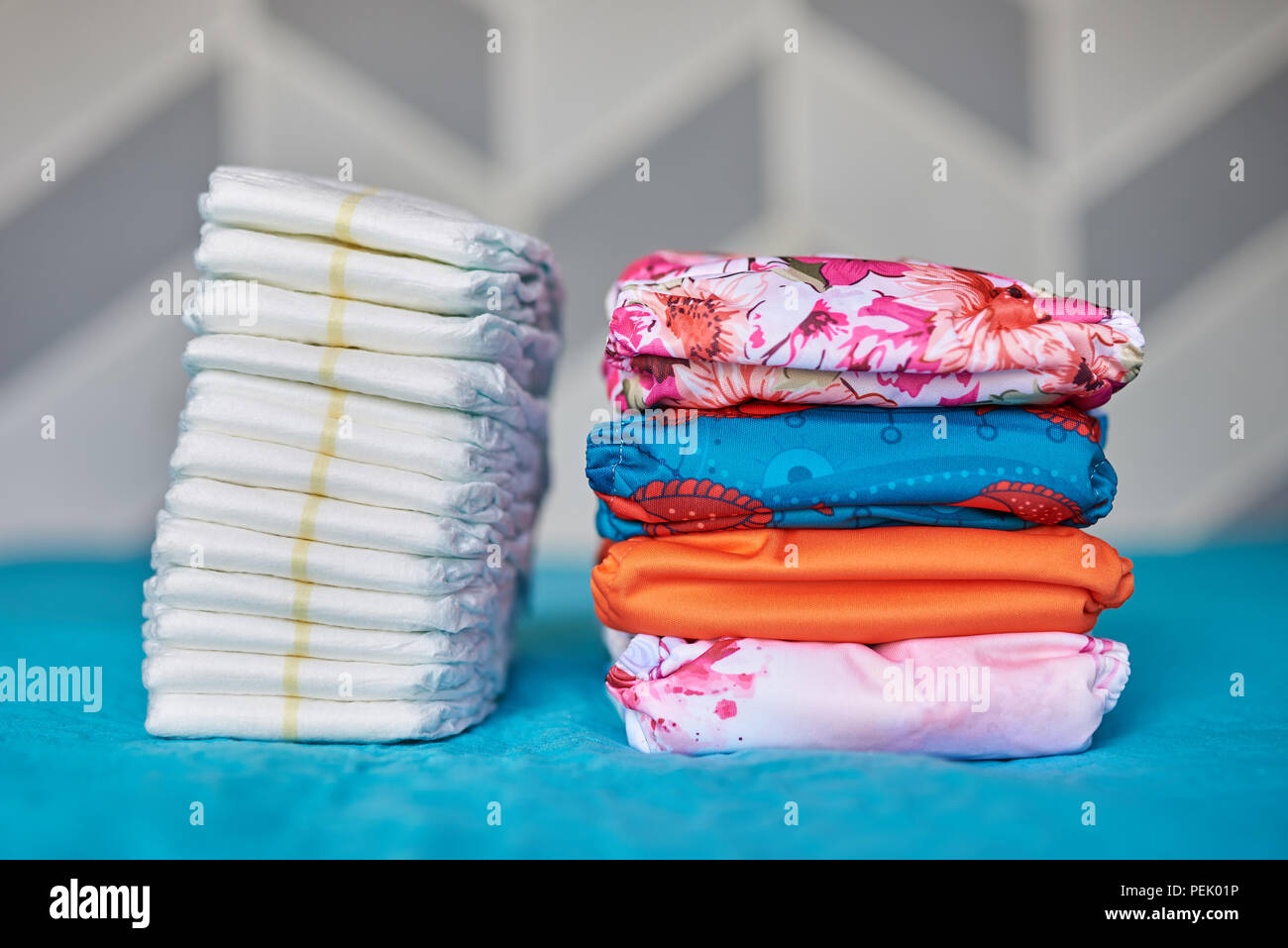 Two piles of diapers. Cloth diaper stack and one time use diaper pile Stock Photo