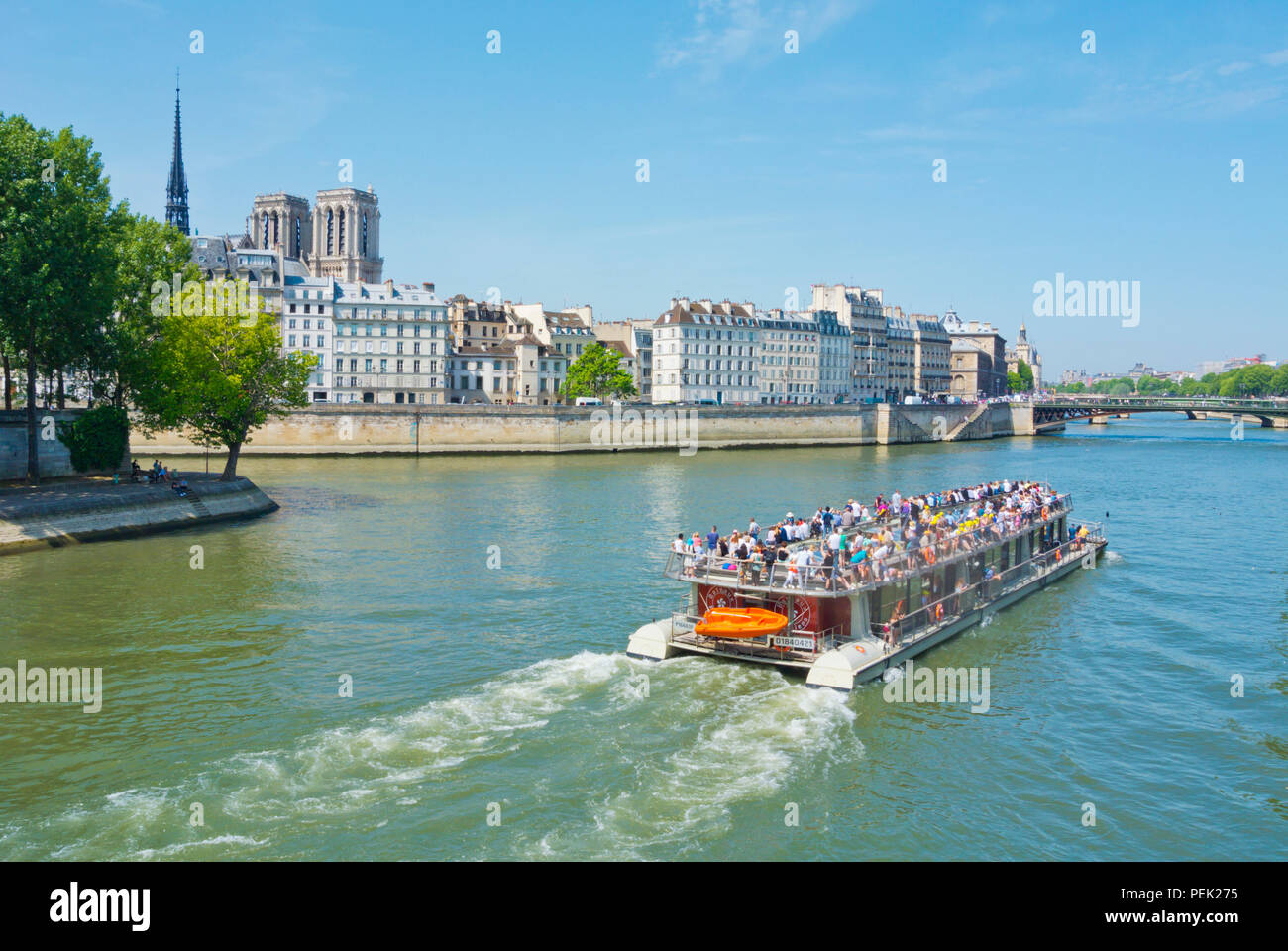 Bateaux Parisiens sightseeing tour boat, in front of Ile de la Cite and Notre Dame, Paris, France Stock Photo