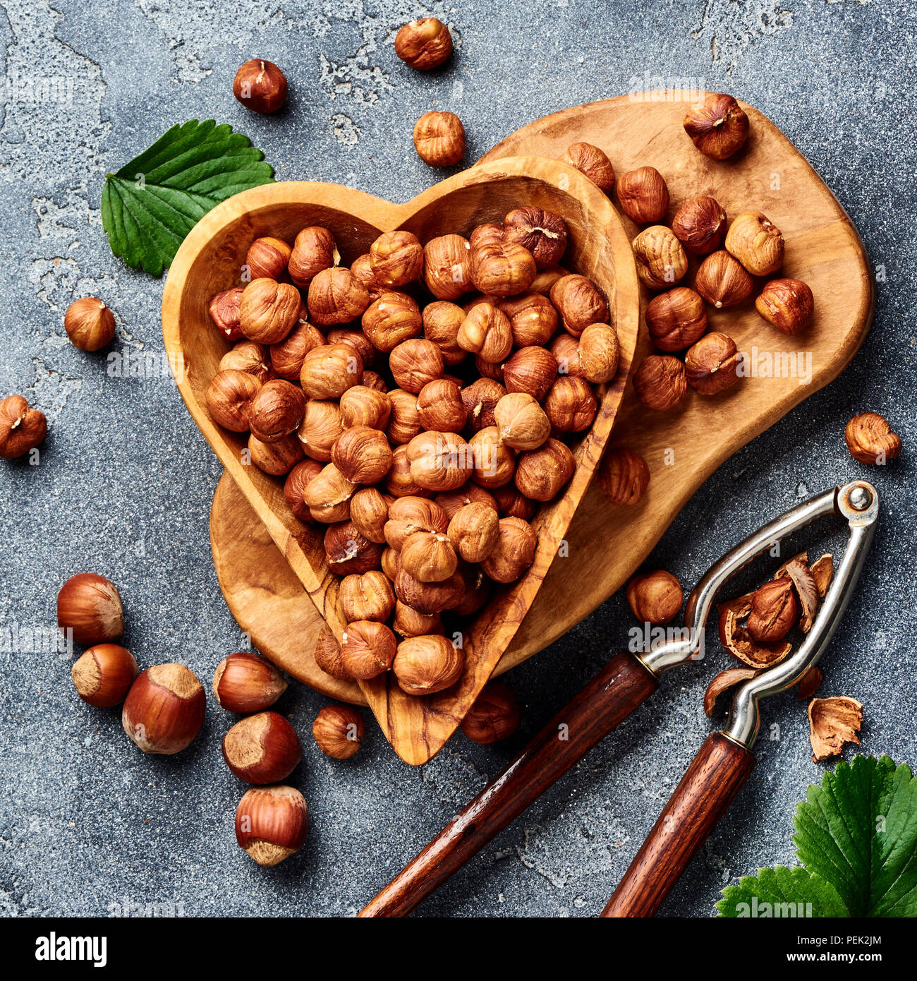 Hazelnuts with nutcracker on gray background. Top view of nuts Stock