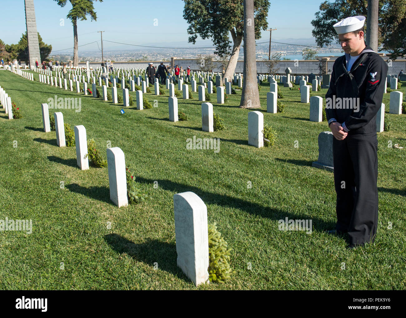 151212-N-QW941-205  SAN DIEGO (Dec. 12, 2015) Information Systems Technician 3rd Class Devon Edmonds pays his respects to fallen military members during the Wreaths Across America ceremony at Fort Rosecran’s National Cemetery. Wreaths Across America is an annual event that takes place in multiple locations where volunteers lay wreaths on tombstones of fallen military members. (U.S. Navy photo by Mass Communication Specialist 3rd Class Trevor Kohlrus/Released) Stock Photo