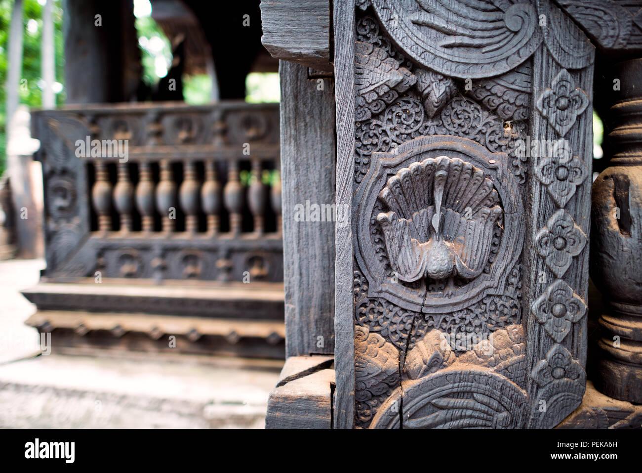 INWA (AVA), Myanmar — Intricate wood carvings in teak decorate the Bagaya Monastery in Inwa, Myanmar. Bagaya Monastery (also known as Bagaya Kyaung) was built in 1834 during the reign of King Bagyidaw. It is constructed entirely of teak, with 267 giant teak posts, the largest of which is 60 feet high and 9 feet in circumference. It is located in the old royal capital region of Inwa (Ava), not far from Mandalay. Stock Photo