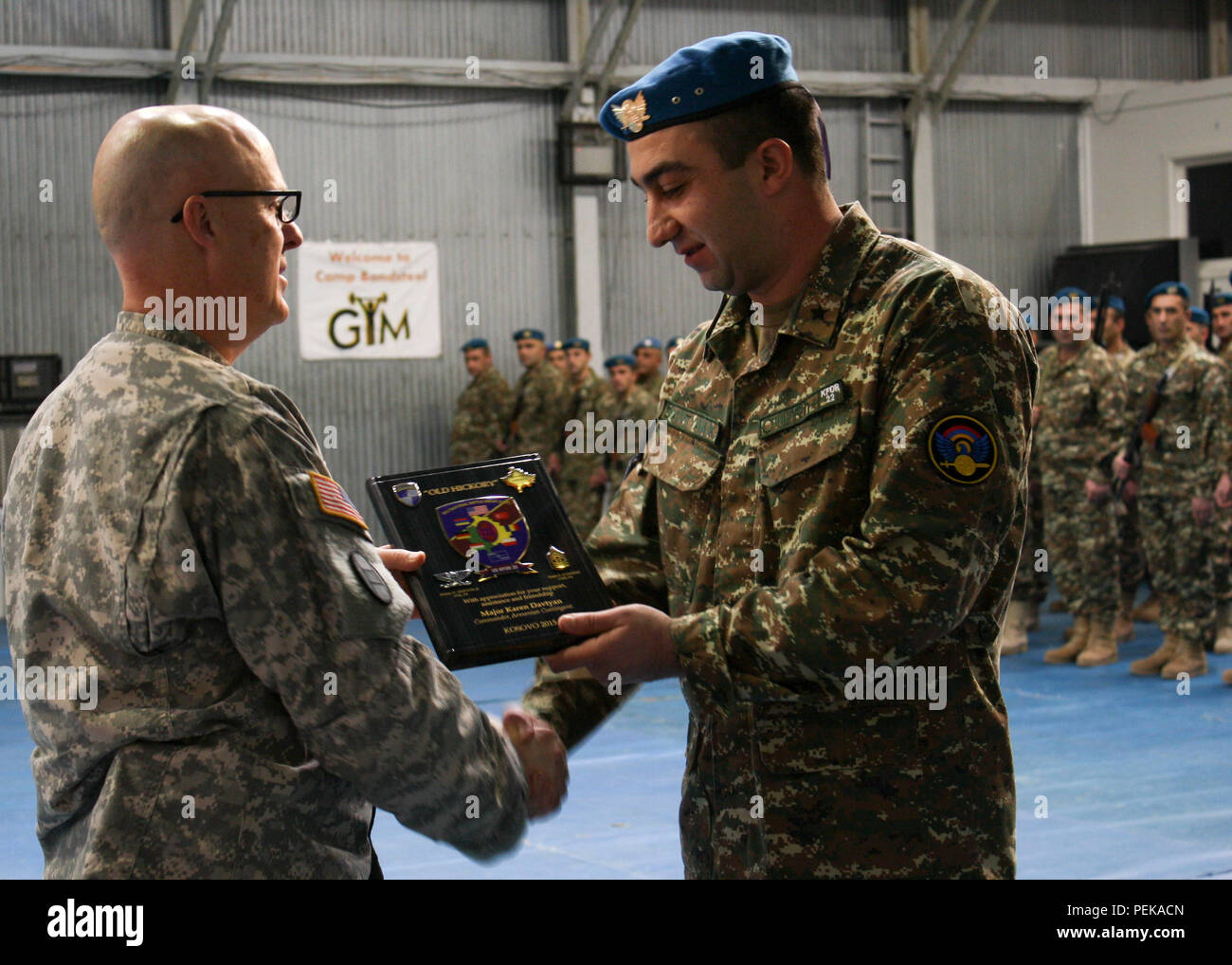 U.S. Army Col. Vernon Simpson, commander of Multinational Battle Group-East  and the North Carolina National Guard's 30th Armored Brigade Combat Team,  presents an honorary plaque to Maj. Karen Davtyan, commander of the