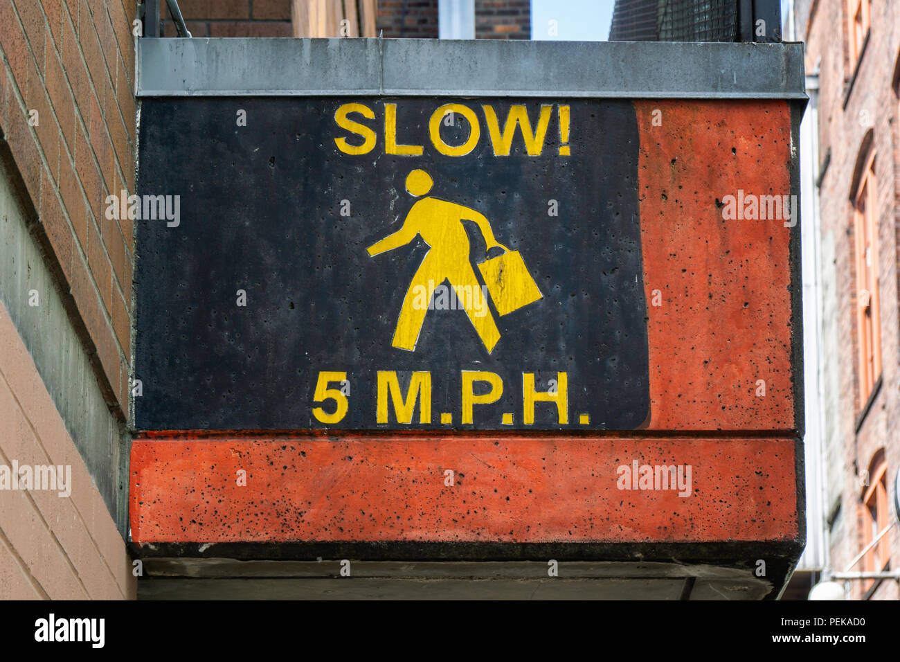 Painted 5 mph speed limit street sign for pedestrians requested to slow down in the streets of Seattle, Washington, USA. Stock Photo
