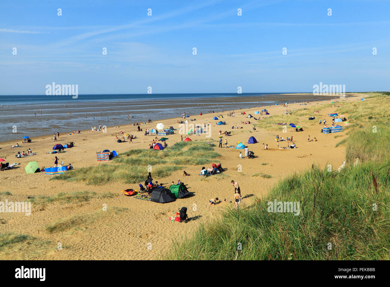 Old Hunstanton, beach, sand, bay, sunbathers, sunbeds, North Sea, coast, Norfolk, England, UK Stock Photo