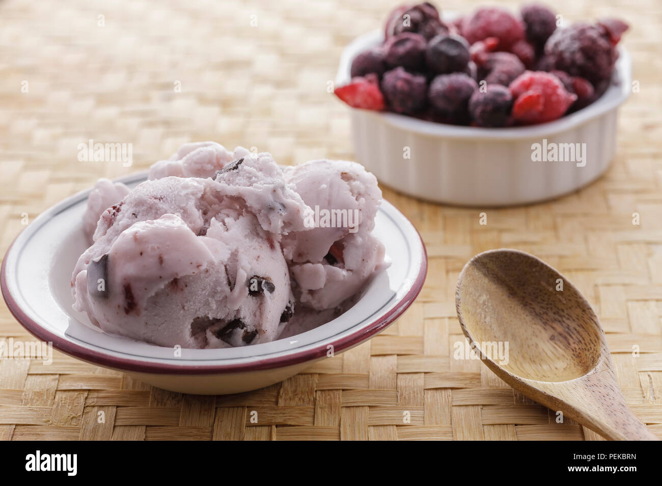A bowl of cherry chocolate chunk ice cream and a bowl of frozen fruit ...