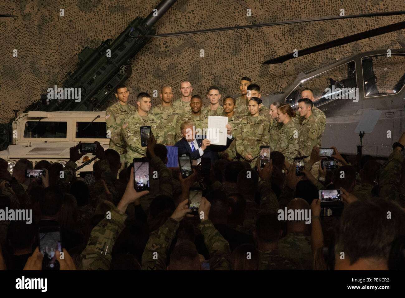 U.S President Donald Trump holds up the John McCain National Defense Authorization Act surrounded by soldiers from the 10th Mountain Division August 13, 2018 in Fort Drum, New York. Stock Photo