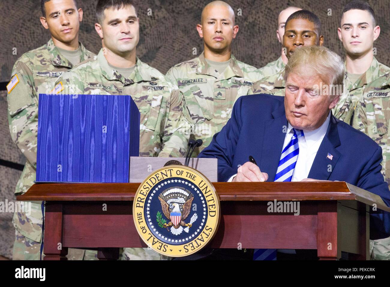 U.S President Donald Trump signs the John McCain National Defense Authorization Act surrounded by soldiers from the 10th Mountain Division August 13, 2018 in Fort Drum, New York. Stock Photo