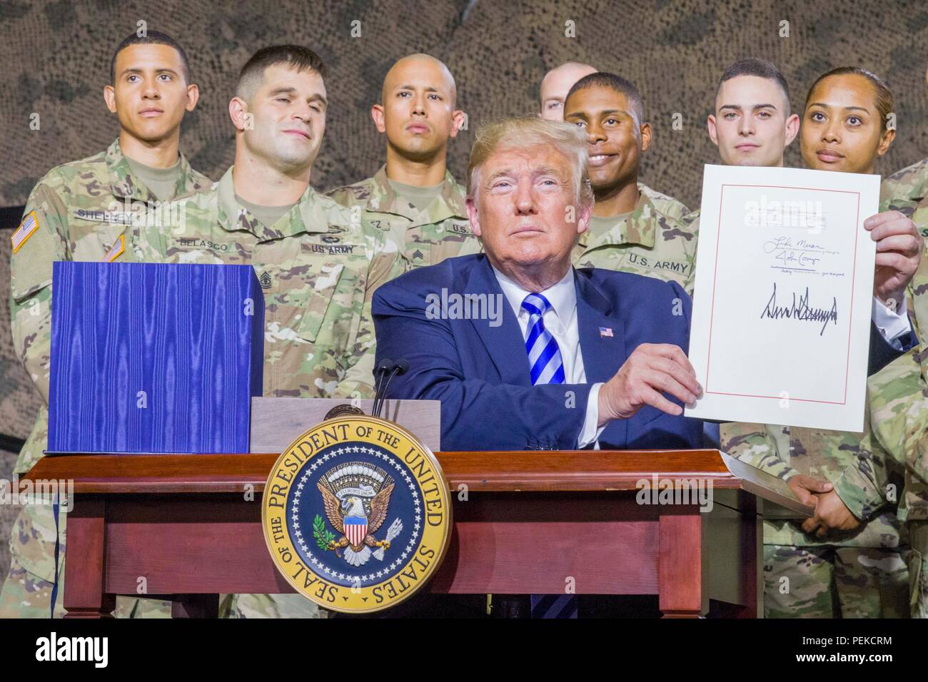 U.S President Donald Trump holds up the John McCain National Defense Authorization Act surrounded by soldiers from the 10th Mountain Division August 13, 2018 in Fort Drum, New York. Stock Photo