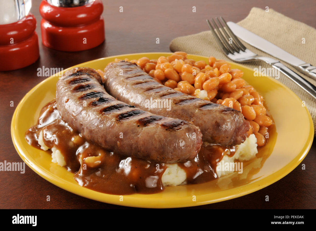 Bangers and mash with onion mushroom gravy and baked beans Stock Photo