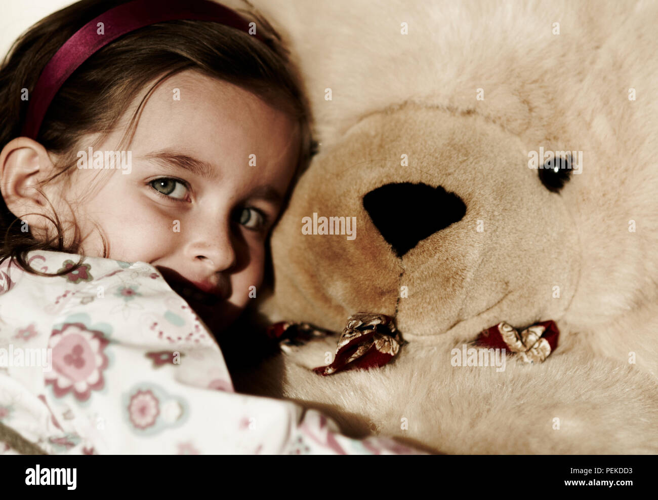 girl cuddling with giant teddy bear