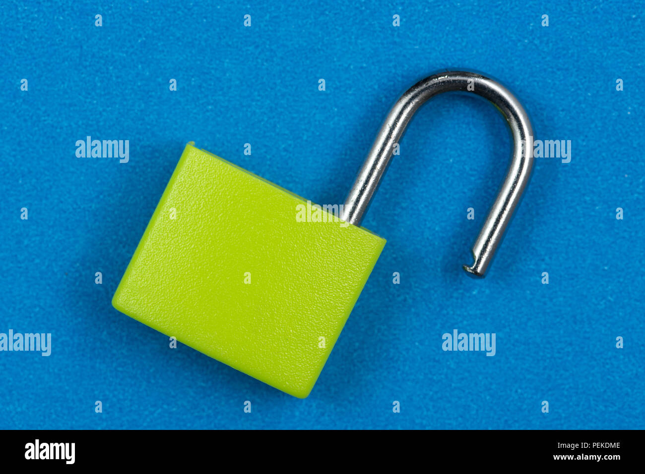 Green padlock isolated on blue background Stock Photo