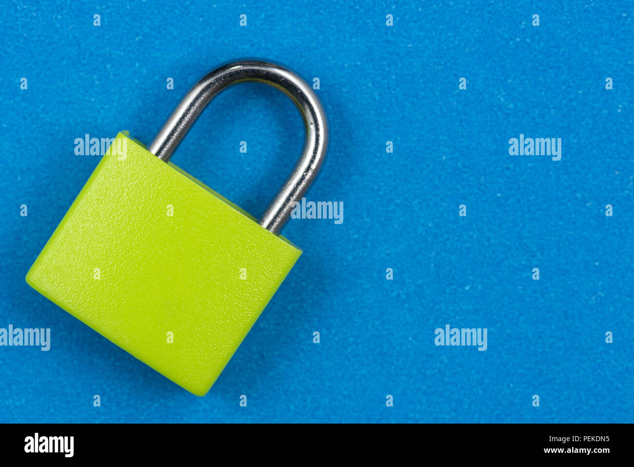 Green padlock isolated on blue background Stock Photo