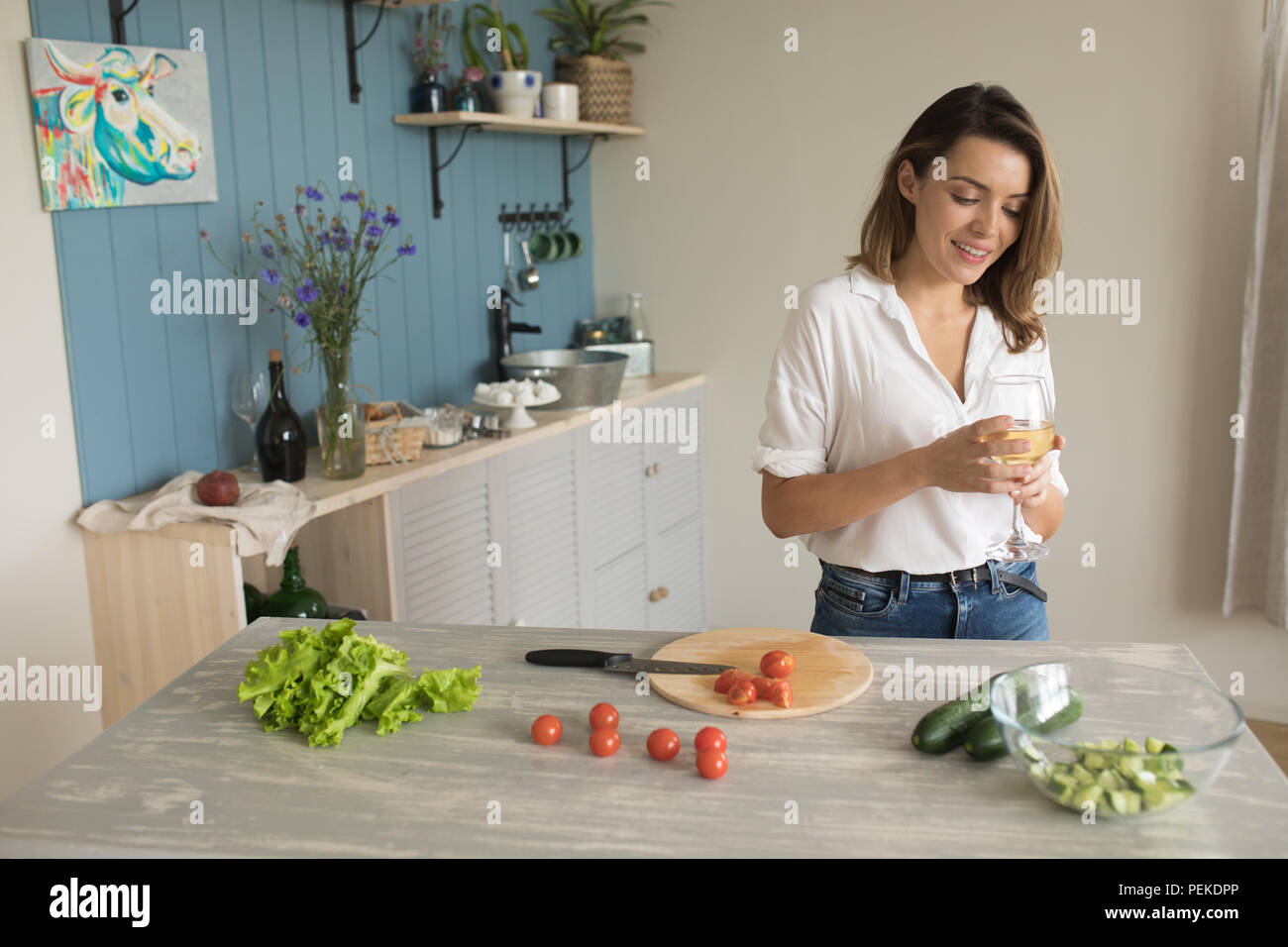 Woman drinking wine while cooking in the kitchen Stock Photo Alamy