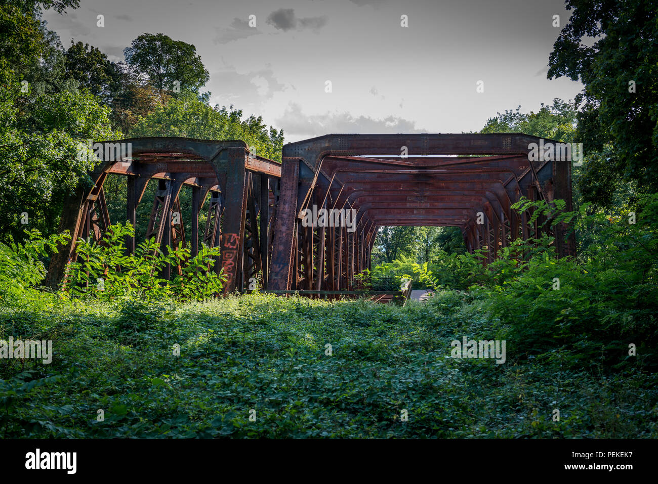 Rusty old railroad bridge that is abandoned in the forest Stock Photo