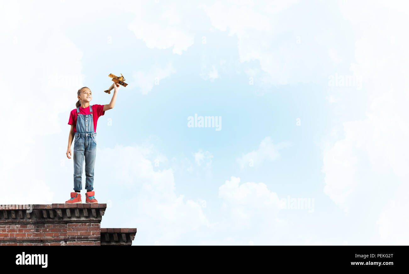 Concept of careless happy childhood with girl dreaming to become pilot Stock Photo
