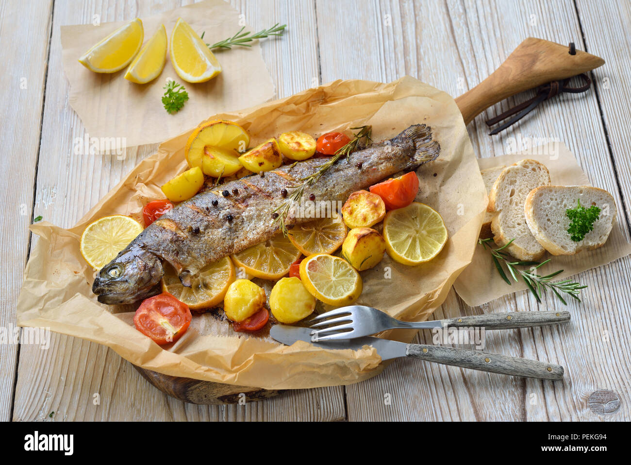 Baked lemon trout with ovenroasted rosemary potatoes and tomatoes