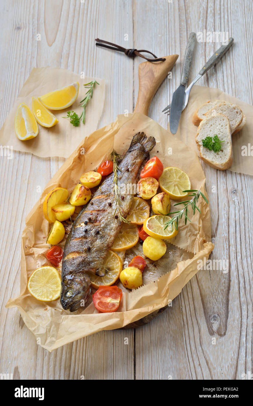 Baked lemon trout with ovenroasted rosemary potatoes and tomatoes