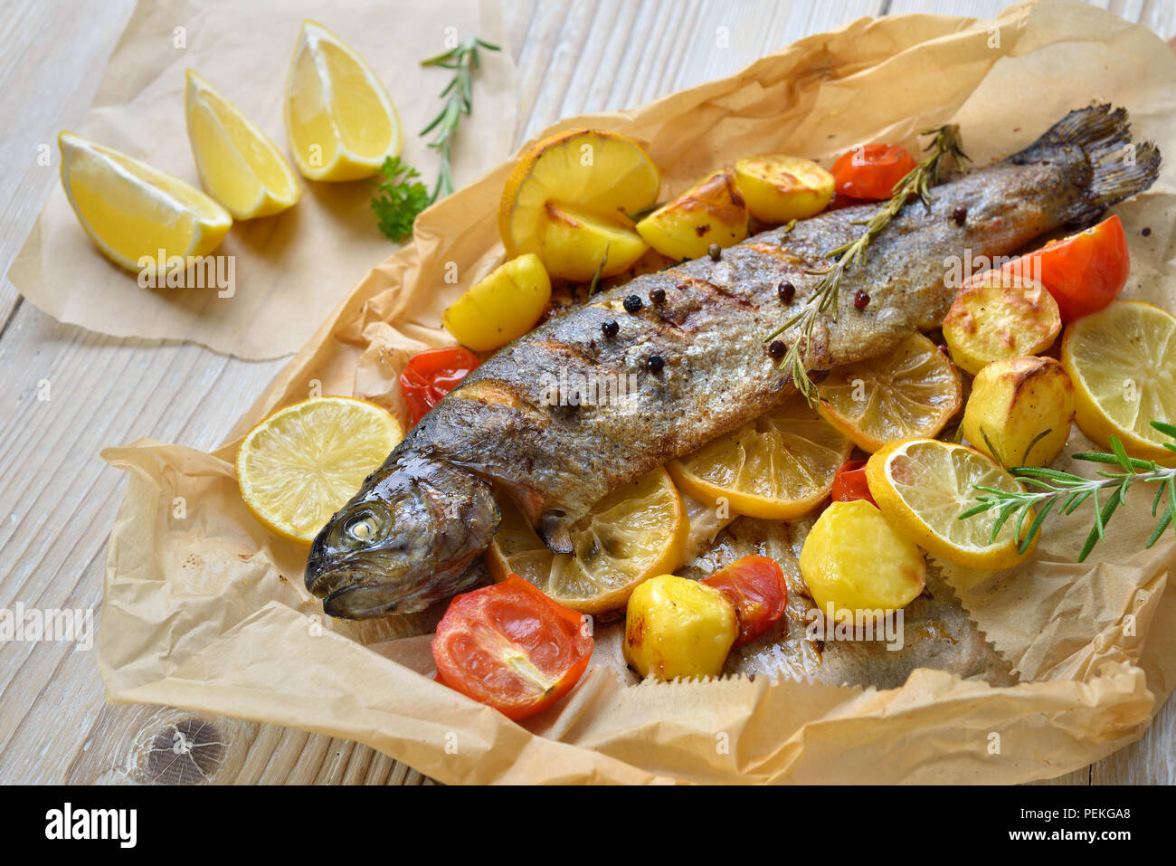 Baked lemon trout with ovenroasted rosemary potatoes and tomatoes