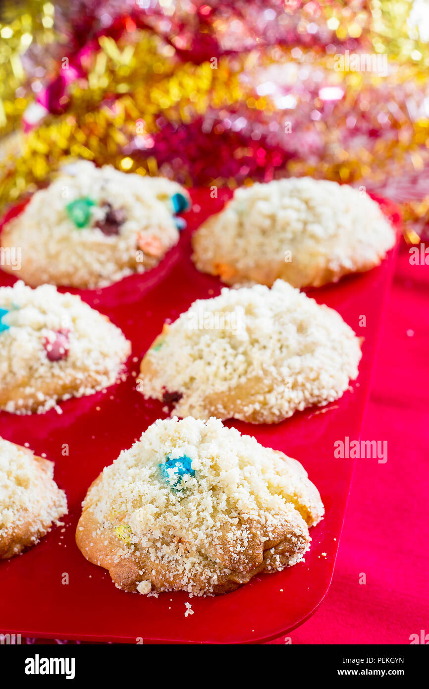 Streusel Muffins in red silicon mold. Christmas concept. Red background with tinsel. Selective focus. Shallow depth of field Stock Photo