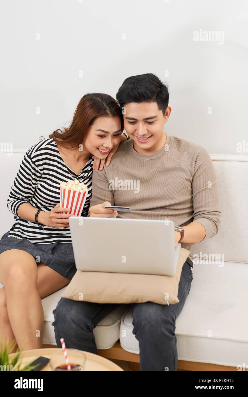 Young couple surfing on internet with laptop. Modern white apartment in background Stock Photo