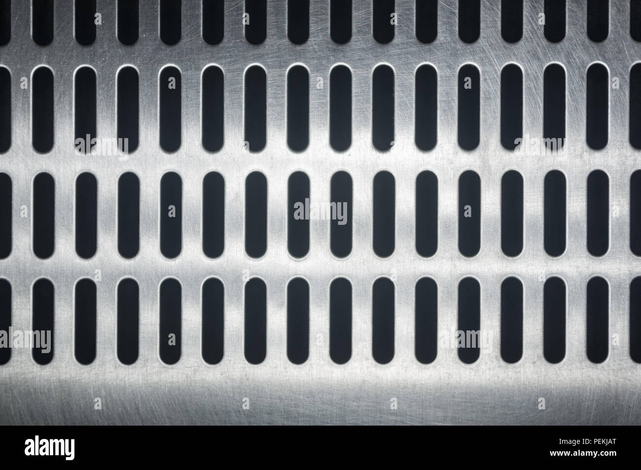 stainless steel grating with oblong holes on black background, close-up Stock Photo