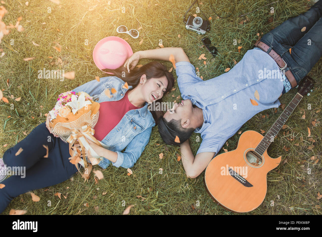 top view of happy love couple laying on green grass Stock Photo - Alamy