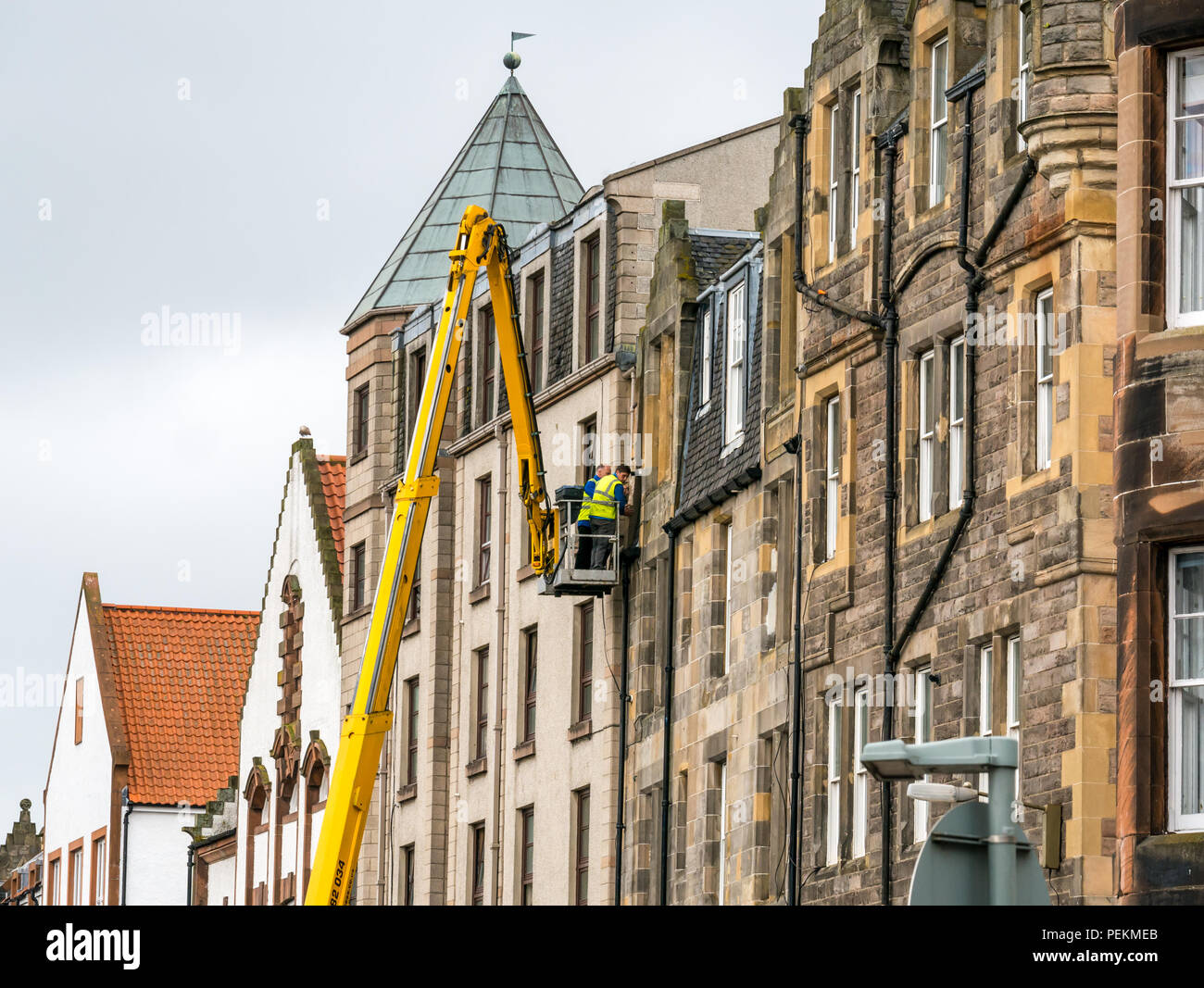 High level cherry picker with workmen repairing downpipe, The Shore, Leith, Edinburgh, Scotland, UK Stock Photo