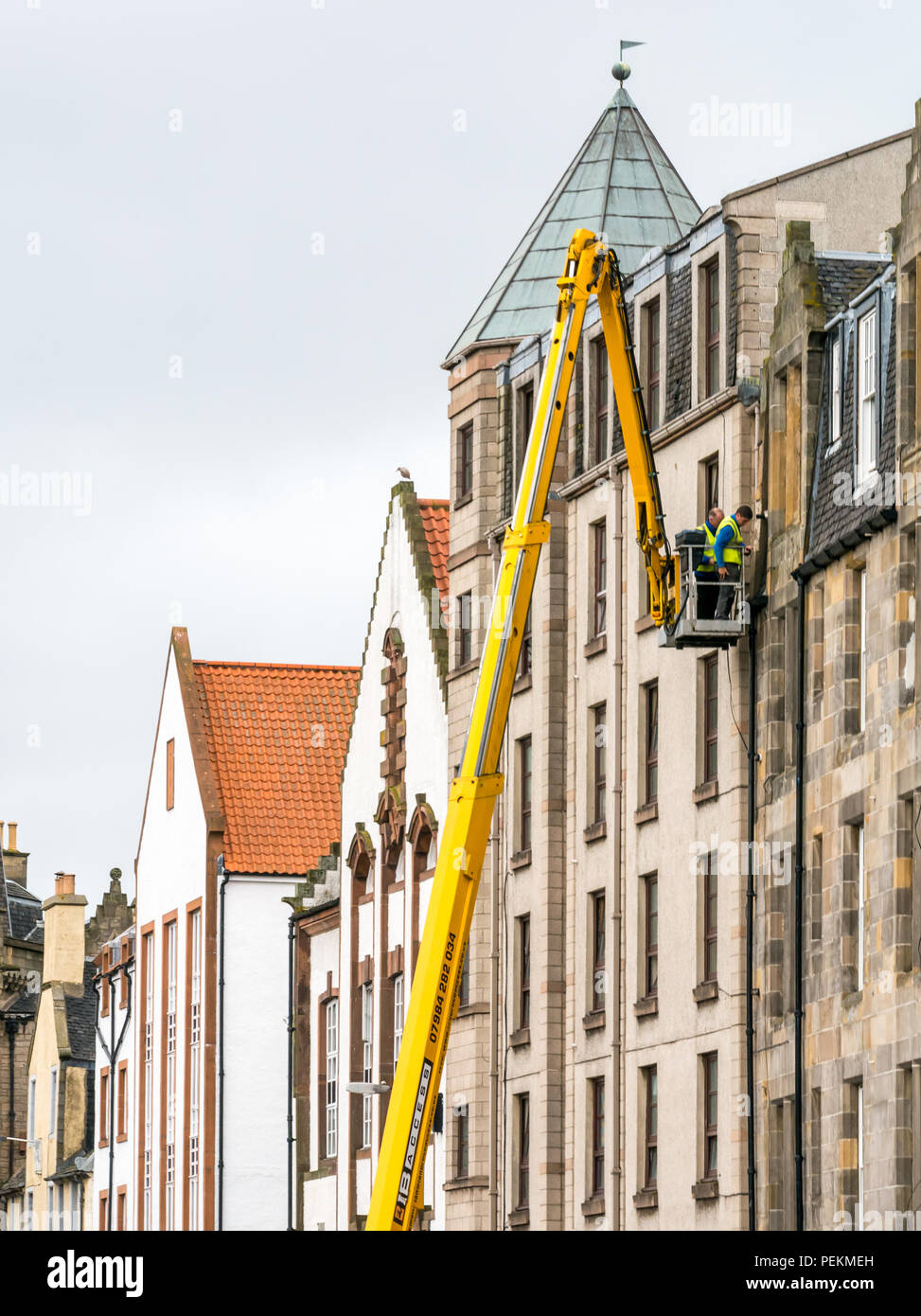 High level cherry picker with workmen repairing downpipe, The Shore, Leith, Edinburgh, Scotland, UK Stock Photo