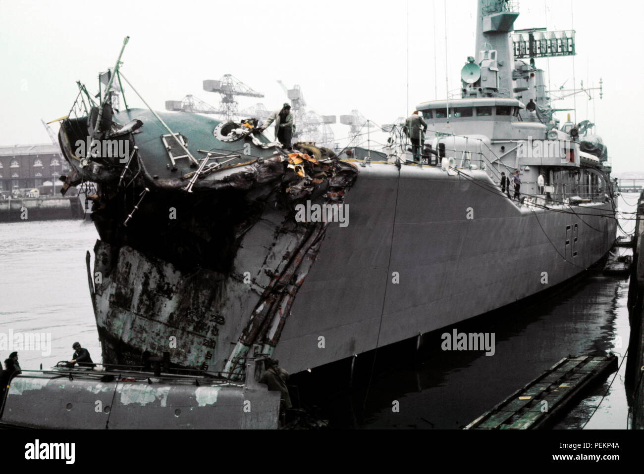 AJAXNETPHOTO. 13TH NOVEMBER, 1975. PORTSMOUTH, ENGLAND. - CRUNCH! - PICTURED ALONGSIDE AT THE NAVAL BASE DOCKYARD WITH 14 FEET OF HER BOW SMASHED; THE GP LEANDER CLASS FRIGATE HMS ACHILLES (2500 TONS). THE FRIGATE COLLIDED WITH LIBERIAN OIL TANKER OLYMPIC ALLIANCE 1 MILES S.E. OF DOVER NEAR VARNE LIGHTSHIP ON NIGHT OF 12/13 NOV 1975. THREE CREWMEN ON ACHILLES WERE INJURED. PHOTO:JONATHAN EASTLAND/AJAX REF:401279_1 Stock Photo