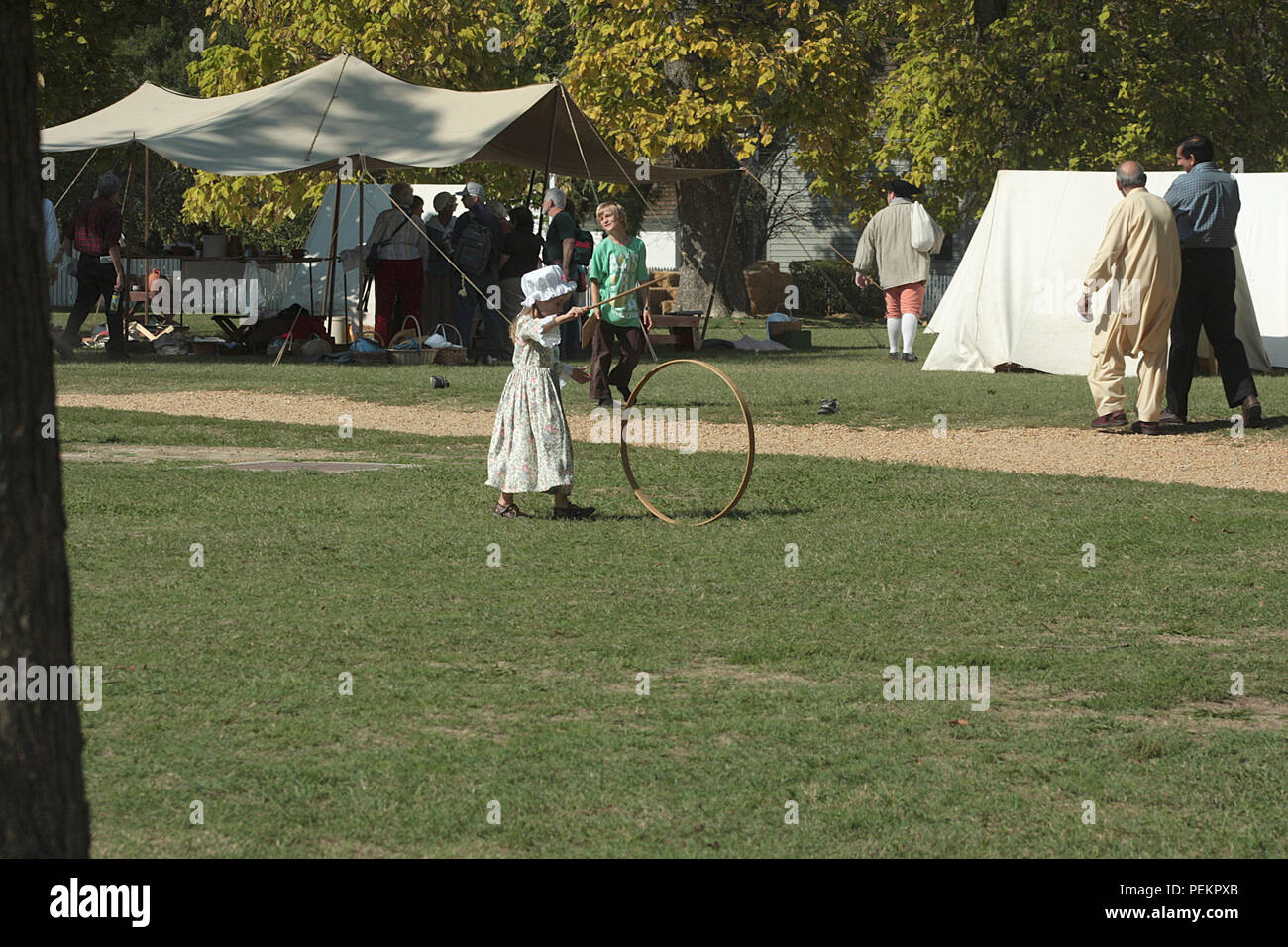 Little child playing hoop and stick in Colonial Williamsburg, Virginia Stock Photo