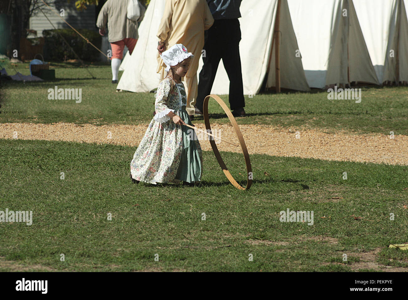 Little child playing hoop and stick in Colonial Williamsburg, Virginia, USA Stock Photo