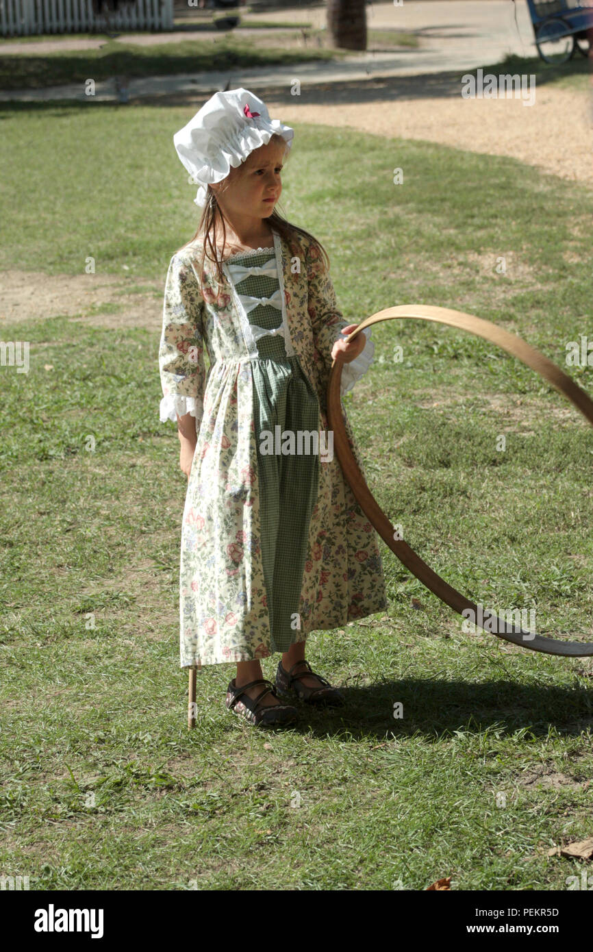 Little child playing hoop and stick in Colonial Williamsburg, Virginia, USA Stock Photo