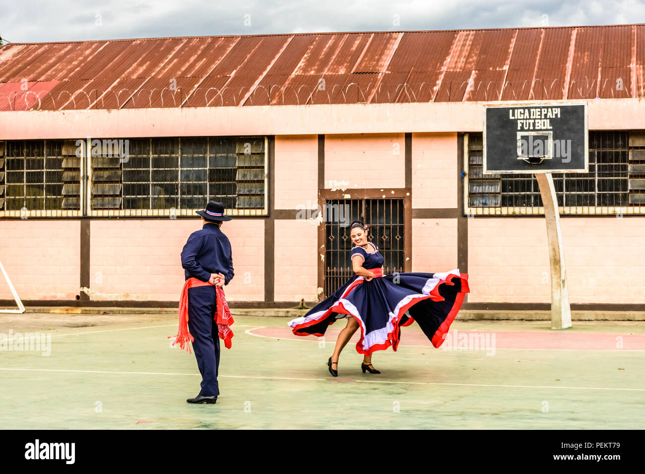San Juan del Obispo, Guatemala -  August 3, 2018: Costa Rican folk dancers perform in basketball court near UNESCO World Heritage Site of Antigua. Stock Photo