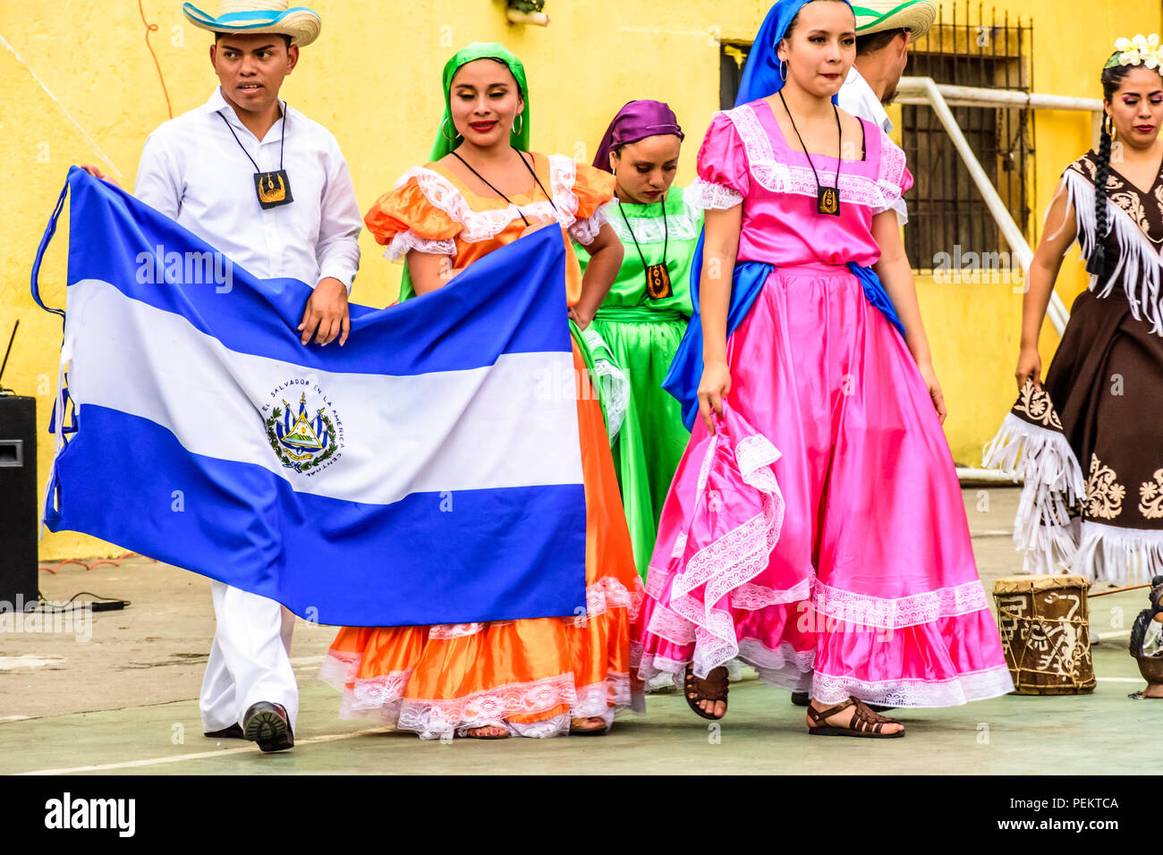 San Juan del Obispo, Guatemala -  August 3, 2018: Folk dancers with El Salvador flag after performing near UNESCO World Heritage Site of Antigua. Stock Photo