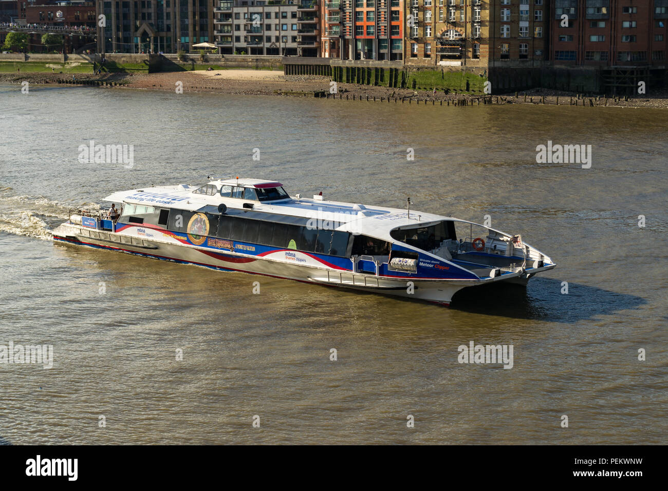 A MBNA Meteor Thames Clipper travelling on the river Thames near Southwark bridge on a sunny Summer afternoon, London, UK Stock Photo