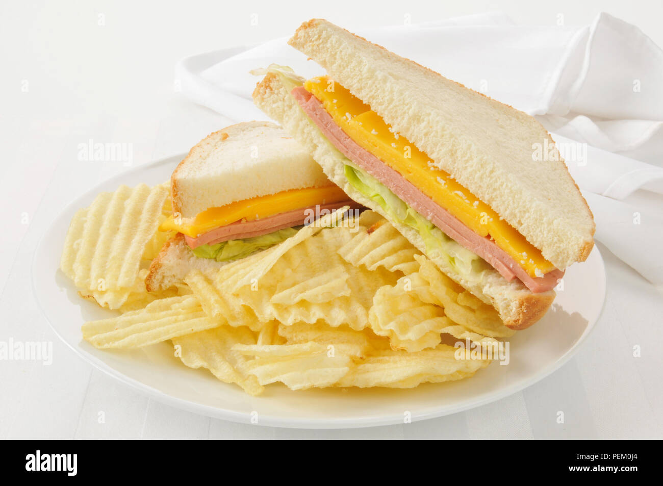 High key photo of a baloney and cheese sandwich with potato chips Stock