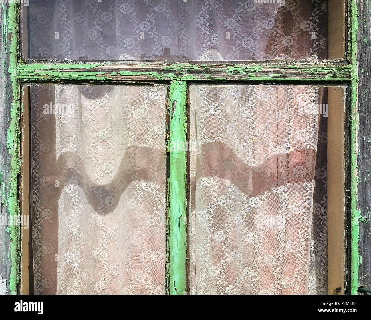 Old wooden window frame with peeling green paint, shades and shadows on ...