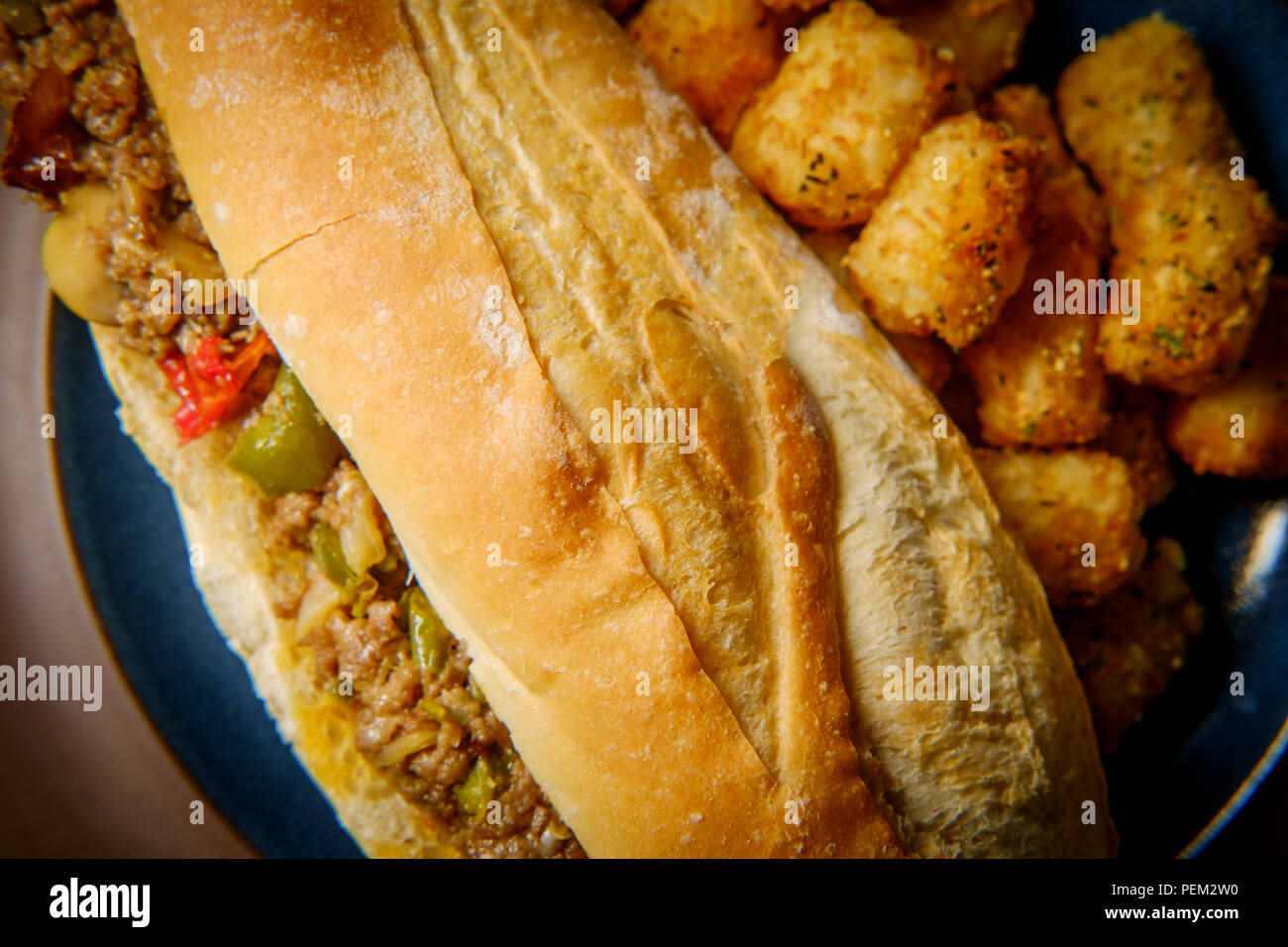 Philly Cheesesteak with diced onions peppers and mushrooms with tater