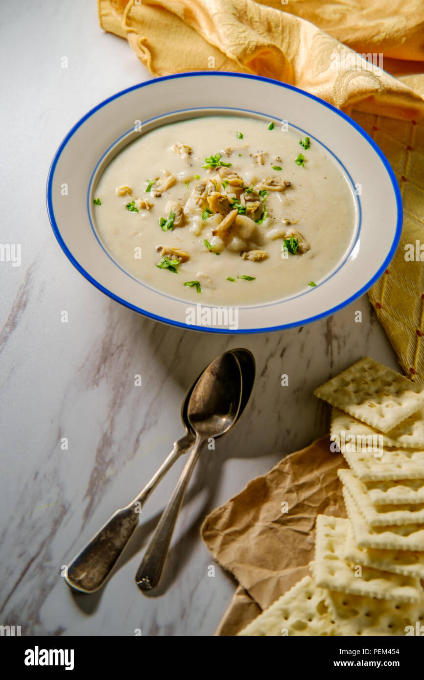 Fresh hot New England clam chowder soup with saltine crackers and
