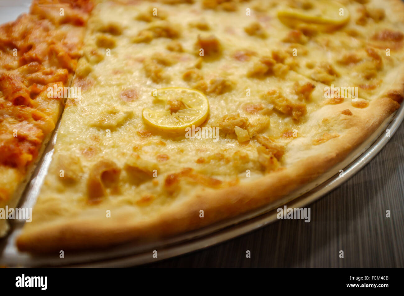 Large slices of cheese pizza with chicken francese topping Stock Photo Alamy