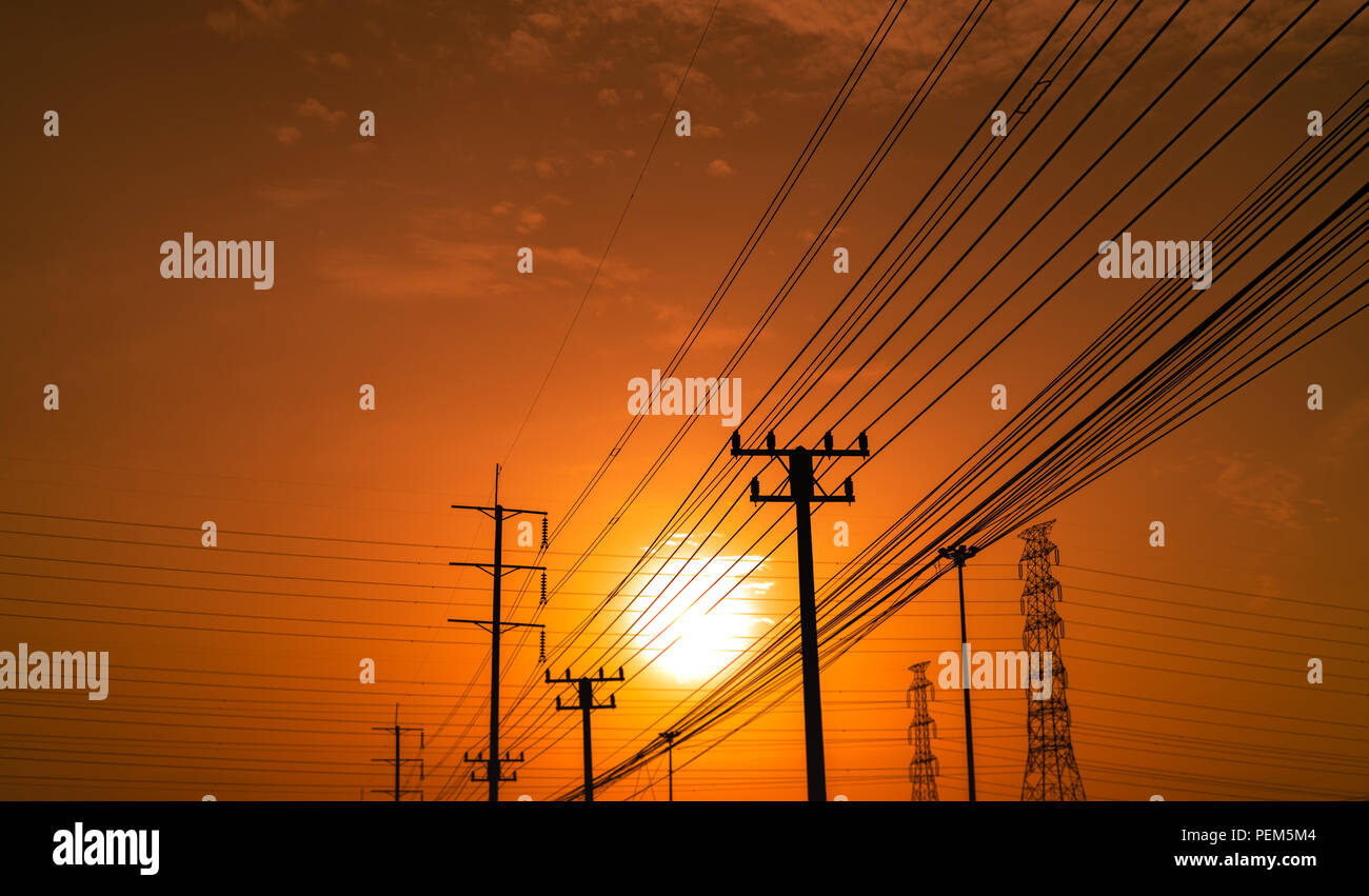 High voltage electric pole and transmission lines at sunset time with ...
