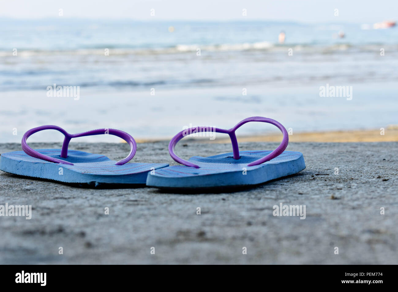 Blue sandal flip-flop on the beach with blue sea and sky background in ...