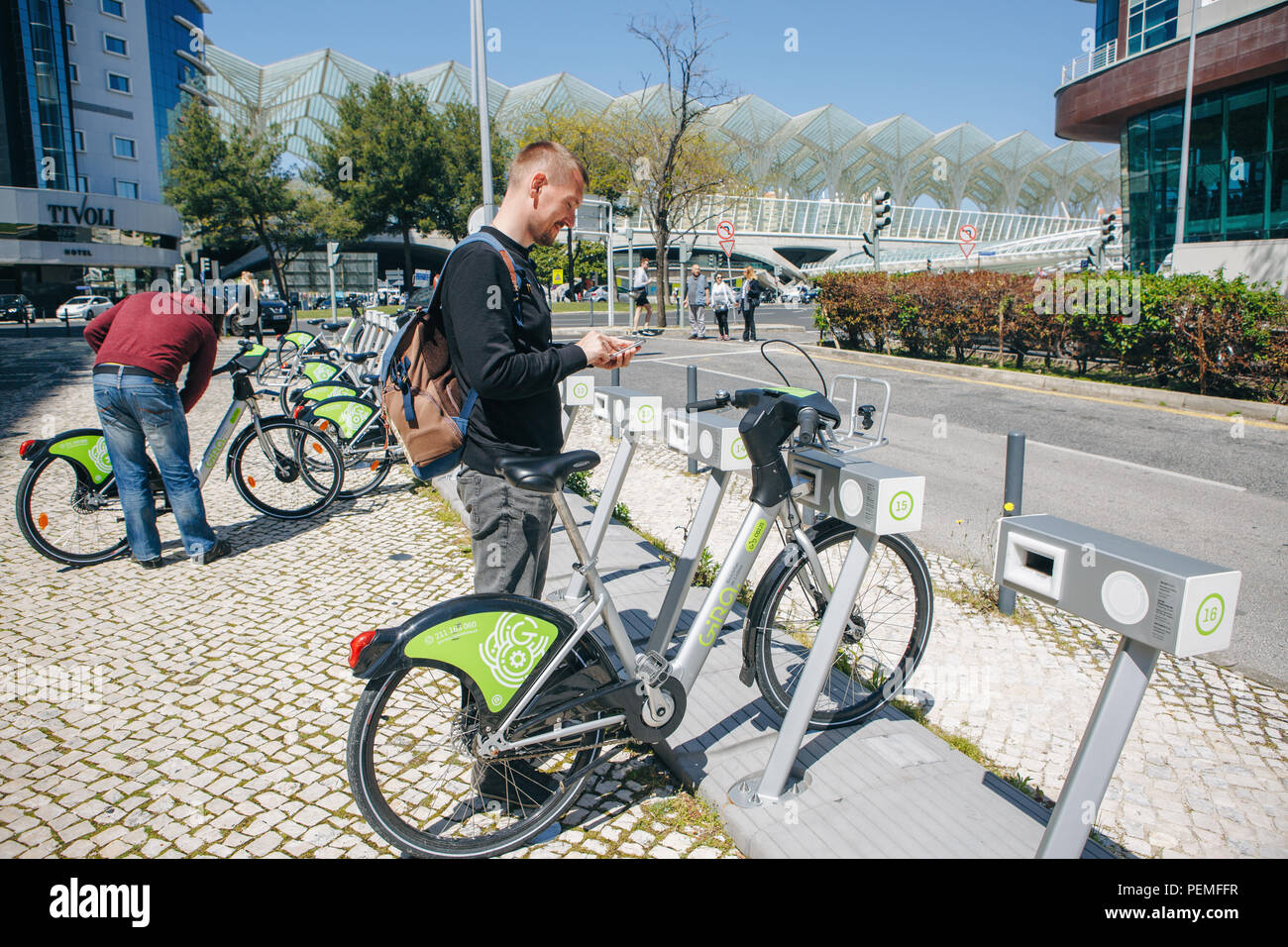 Portugal, Lisbon 29 april 2018: man or tourist rents bicycle or city alternative ecological transport using the mobile app on your phone Stock Photo