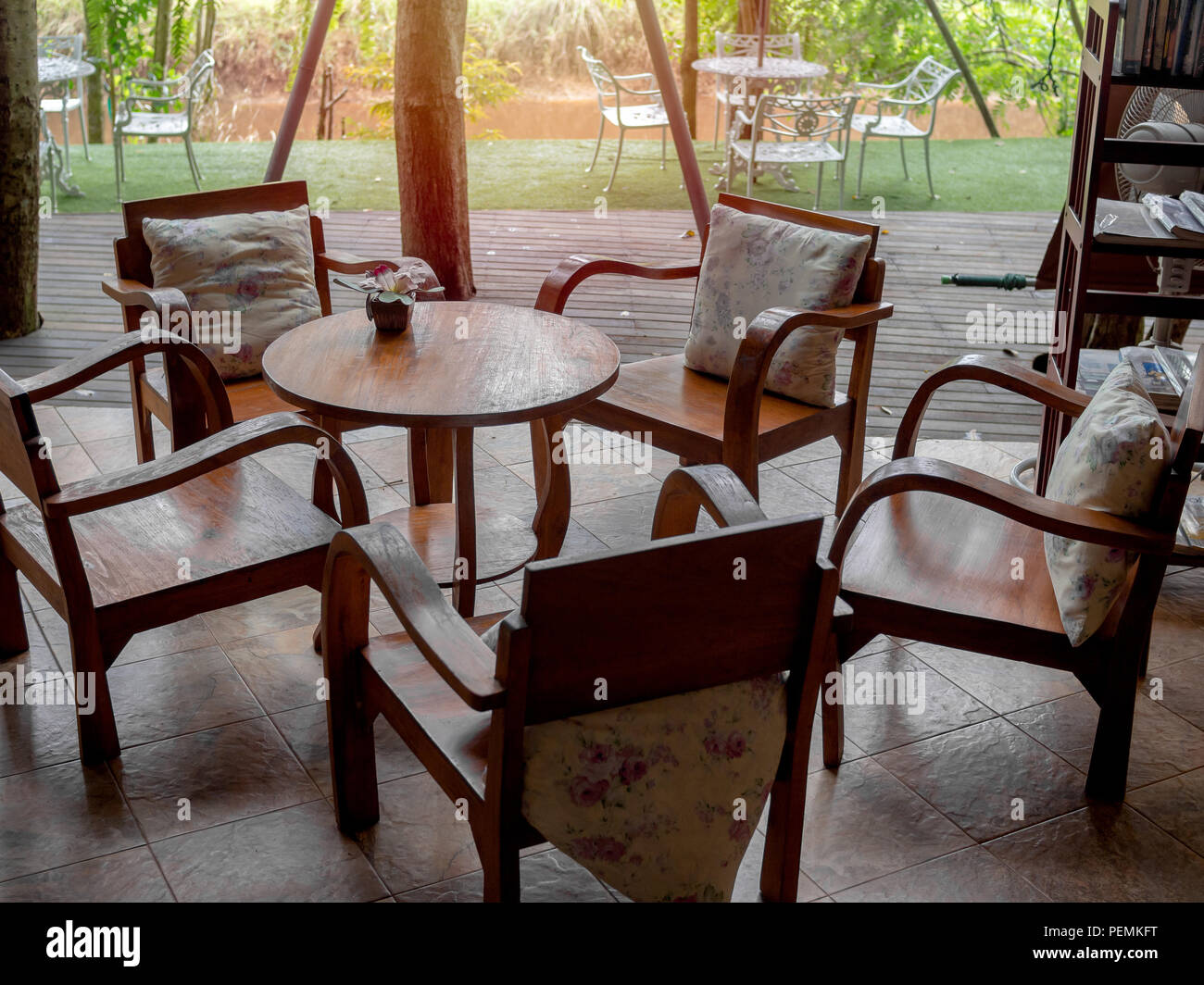 Wooden Armchairs With Pillows Round Wooden Table With Flower In